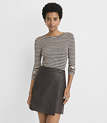 A woman in a striped shirt and a brown leather skirt stands against a plain, light gray background. carousel Product Image 1