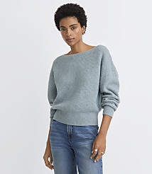 A woman in a light blue sweater and jeans stands against a plain white background. carousel Product Image 1