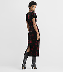 A woman in a black velvet dress with red floral print stands against a plain gray background. carousel Product Image 3