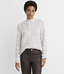 A woman in a light-colored, textured sweater and dark pants stands against a plain, light gray background. carousel Product Image 2