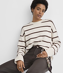 A woman in a striped sweater and dark pants poses against a plain white background. carousel Product Image 1