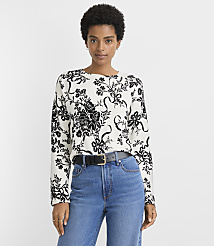 A woman in a floral sweater and jeans stands against a plain white background. carousel Product Image 2