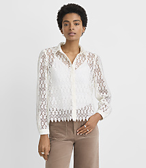 A woman in a white lace blouse and brown pants stands against a plain white background. carousel Product Image 1