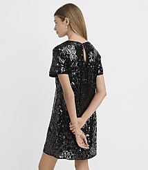 A woman in a sparkling black sequined dress stands with her hands clasped behind her back against a plain white background. carousel Product Image 3