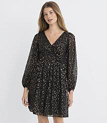 A woman in a black and gold patterned dress stands against a plain white background. carousel Product Image 2