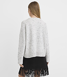 A woman in a speckled gray sweater and a black fringed skirt stands against a plain white background. carousel Product Image 3