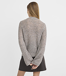 A woman in a light brown, open-knit cardigan and a dark skirt stands with her back to the camera against a plain, light gray background. carousel Product Image 3