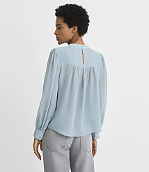 A woman in a light blue blouse and gray pants stands against a plain white background. carousel Product Image 3