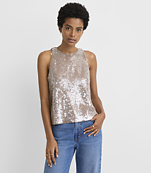 A woman in a sequined top and jeans stands against a plain white background. carousel Product Image 1