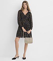 A woman in a black and gold patterned dress and black heeled mules holds a woven handbag in front of a plain white background. carousel Product Image 1