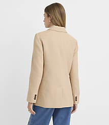 A woman in a tan blazer and blue jeans stands against a plain white background. carousel Product Image 3