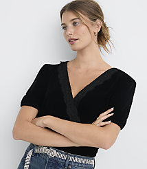 A woman in a black velvet top with lace trim poses with her arms crossed against a plain white background. carousel Product Image 1