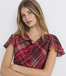 A woman with blonde hair and blue eyes, wearing a red plaid top, is posed against a plain white background. carousel Product Image 3