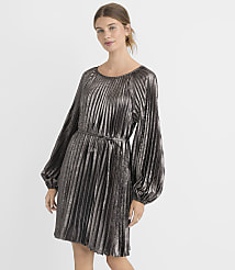 A woman in a silver, pleated, long-sleeved dress stands against a plain white background. carousel Product Image 2