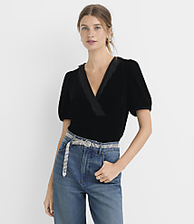 A woman in a black velvet top and jeans stands against a plain white background. carousel Product Image 2