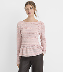 A woman in a pink textured peplum top and dark pants stands against a plain white background. carousel Product Image 2