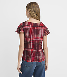 A woman in a red plaid top and blue jeans stands against a plain white background. carousel Product Image 4