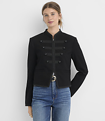 A woman in a black military-style jacket and blue jeans stands against a plain white background. carousel Product Image 1