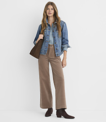 A woman in a denim jacket and corduroy pants stands against a plain white background. carousel Product Image 1