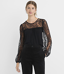 A woman in a black lace-sleeved top and black pants stands against a plain white background. carousel Product Image 1