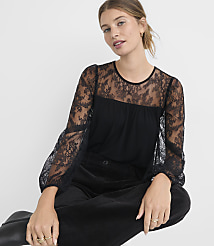 A woman in a black lace-sleeved top and dark pants sits against a plain white background. carousel Product Image 2