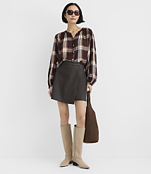 A woman wearing a plaid shirt, a dark grey skirt, and beige boots stands against a plain white background. carousel Product Image 2