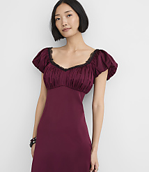 A woman wearing a burgundy dress with puff sleeves stands against a plain white background. carousel Product Image 2