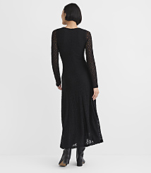 A woman wearing a long-sleeved black lace maxi dress and black boots stands with her back to the camera against a plain white background. carousel Product Image 3