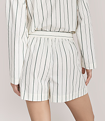 A person wears a white and green vertical striped matching shirt and shorts set against a plain light grey background. carousel Product Image 3