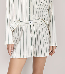 A person wears a matching white and green vertical-striped shirt and shorts set against a plain light gray background. carousel Product Image 2