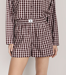 A person wears a matching maroon and white gingham pajama set against a plain light gray background. carousel Product Image 2