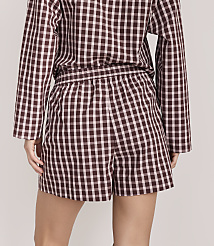 A person wearing a brown and white checkered pajama set stands against a plain, light-colored background. carousel Product Image 3