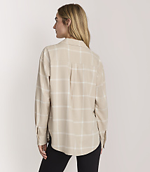 A woman wearing a beige plaid shirt and black pants stands against a plain light-colored background. carousel Product Image 3