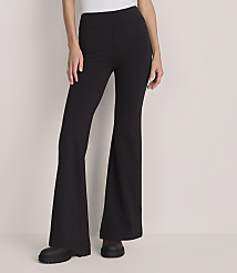 A person wearing black flared trousers and chunky boots stands against a plain, light-colored background. carousel Product Image 2