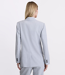 A woman with blonde hair stands with her back to the camera wearing a light blue pinstriped blazer and matching trousers against a plain white background. carousel Product Image 3