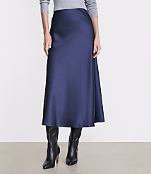 A person wears a long navy blue satin skirt, a grey sweater, and black leather boots against a plain white background. carousel Product Image 2