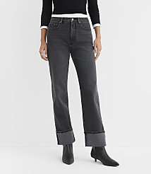 A person stands in the foreground wearing cuffed dark wash jeans and black boots against a plain white background. carousel Product Image 1
