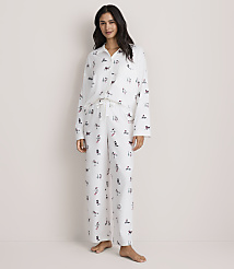 A woman wearing white patterned pajamas stands against a plain, light-colored background. carousel Product Image 2