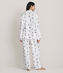 A woman stands with her back to the camera wearing white patterned pajamas against a plain, light-colored background. carousel Product Image 3