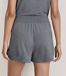 A person wears grey shorts and a matching top against a plain, light-colored background. carousel Product Image 3