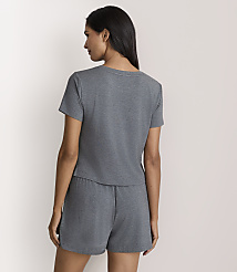 A woman wearing a grey short-sleeved t-shirt and matching shorts stands with her back to the camera against a plain white background. carousel Product Image 3