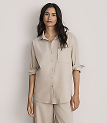 A woman wearing a beige button-down shirt and matching pants stands against a plain, light-colored background. carousel Product Image 2