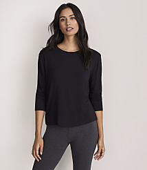 A woman wearing a black long-sleeved top and dark grey leggings stands against a plain, light-colored background. carousel Product Image 2