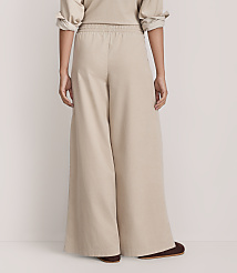 A person wearing wide-leg beige trousers and a matching top stands against a plain, light-colored background. carousel Product Image 3