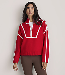 A woman wearing a red and white quarter-zip sweater and brown leggings stands against a plain, light-colored background. carousel Product Image 1