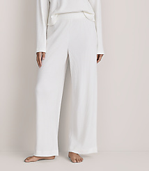 A person wearing a white ribbed knit matching set stands barefoot against a plain, light-colored background. carousel Product Image 2