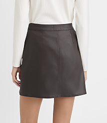 A person wears a white ribbed top and a dark brown faux-leather mini skirt against a plain white background. carousel Product Image 3