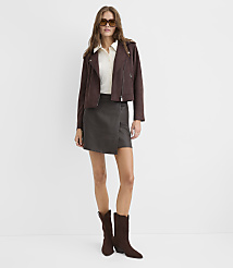 A woman wearing a brown jacket, white shirt, grey skirt, and brown boots stands against a plain white background. carousel Product Image 1