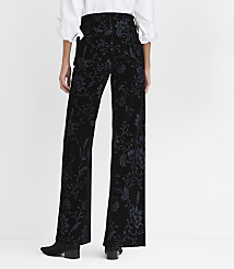 A person wearing a white blouse and black floral-patterned trousers stands against a plain white background. carousel Product Image 3