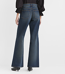 A person wearing a black top and wide-leg blue jeans stands against a plain white background. carousel Product Image 2